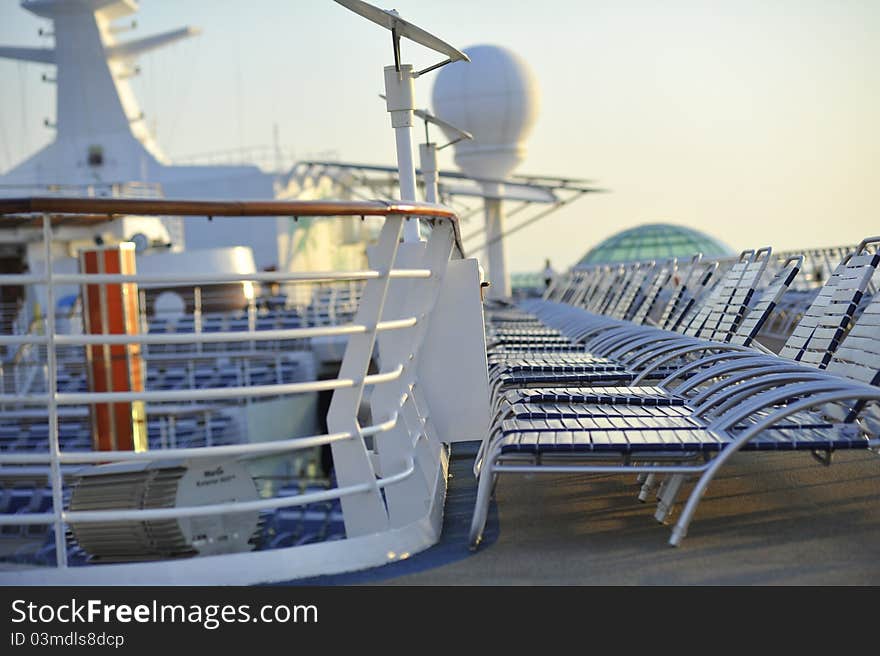 A row of deck chairs on a cruiseship waiting to start the load of a promising new day. A row of deck chairs on a cruiseship waiting to start the load of a promising new day