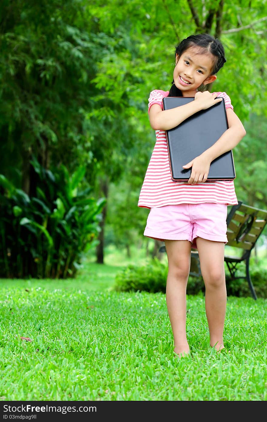 Girl with laptop in the park outside the home. With a cheerful, fun. Girl with laptop in the park outside the home. With a cheerful, fun