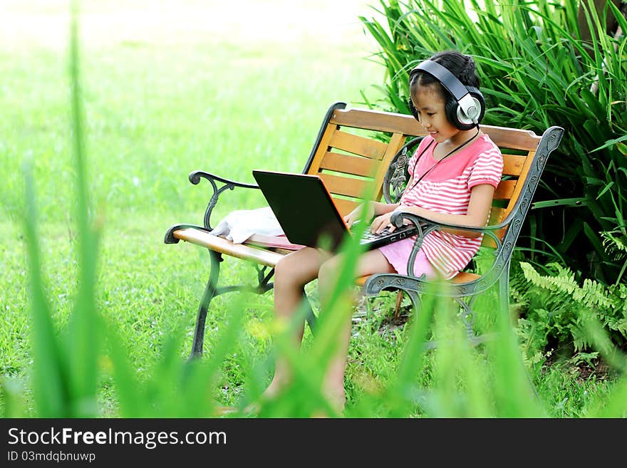 Girl with a laptop in the park grass