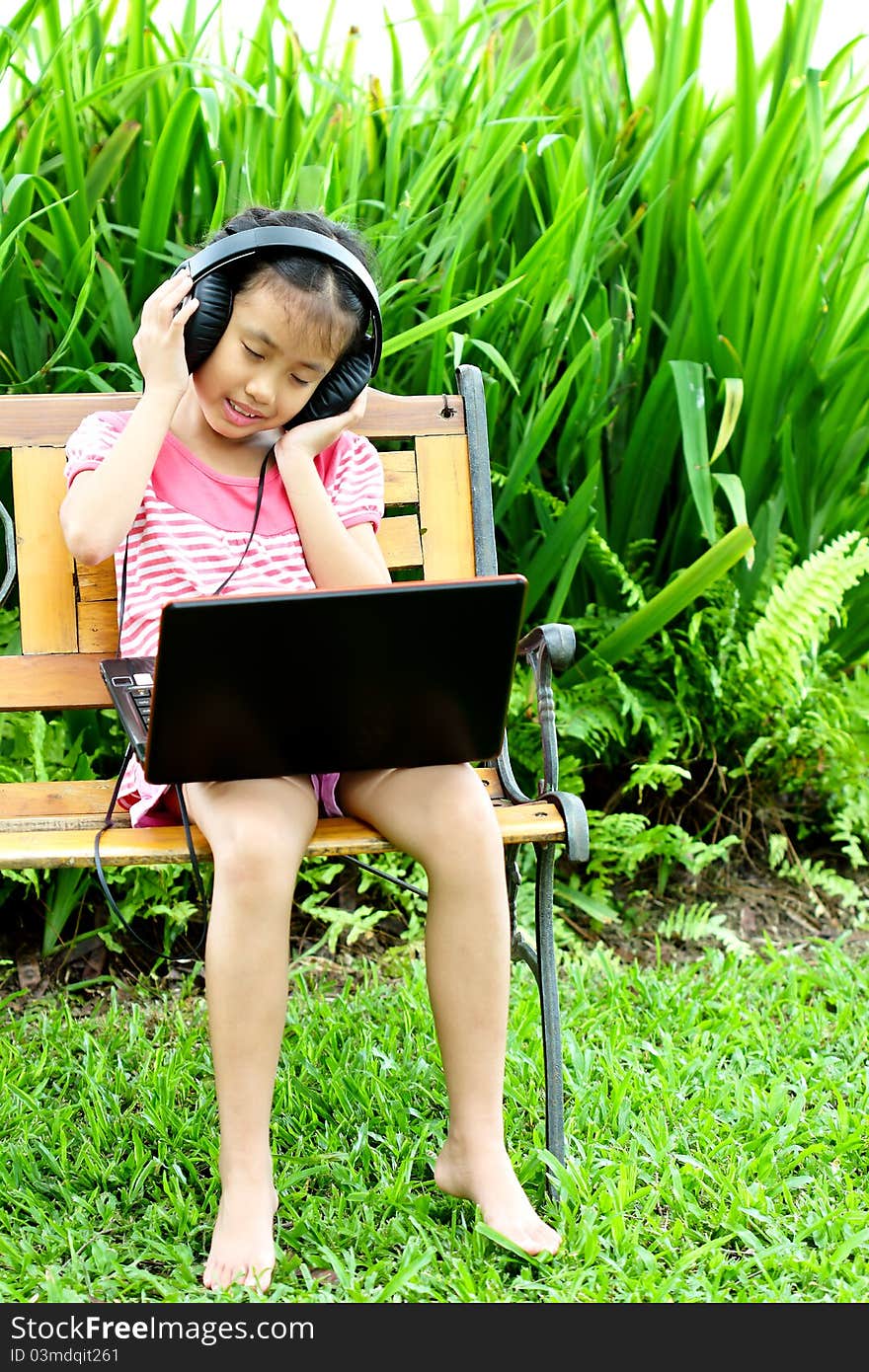 Girl listening to music from a laptop