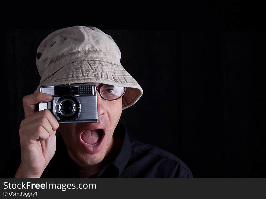 Photographer with hat an old camebra on black background