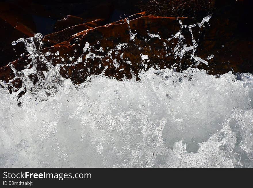 An abstract o splashing water and red rocks. An abstract o splashing water and red rocks