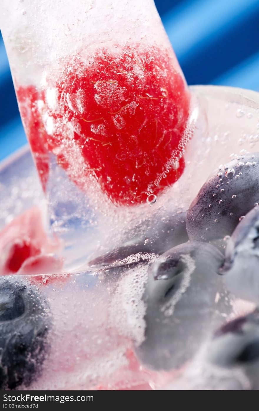 Raspberry and blackberry frozen in ice sticks with drink