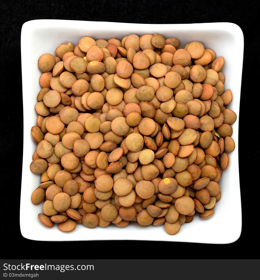 Lentil In A White Bowl Isolated On Black