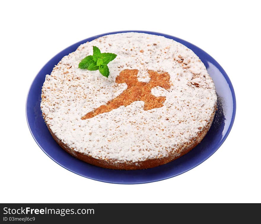 Nut cake dusted with powdered sugar (symbol on a top) on a blue plate - cut out on white