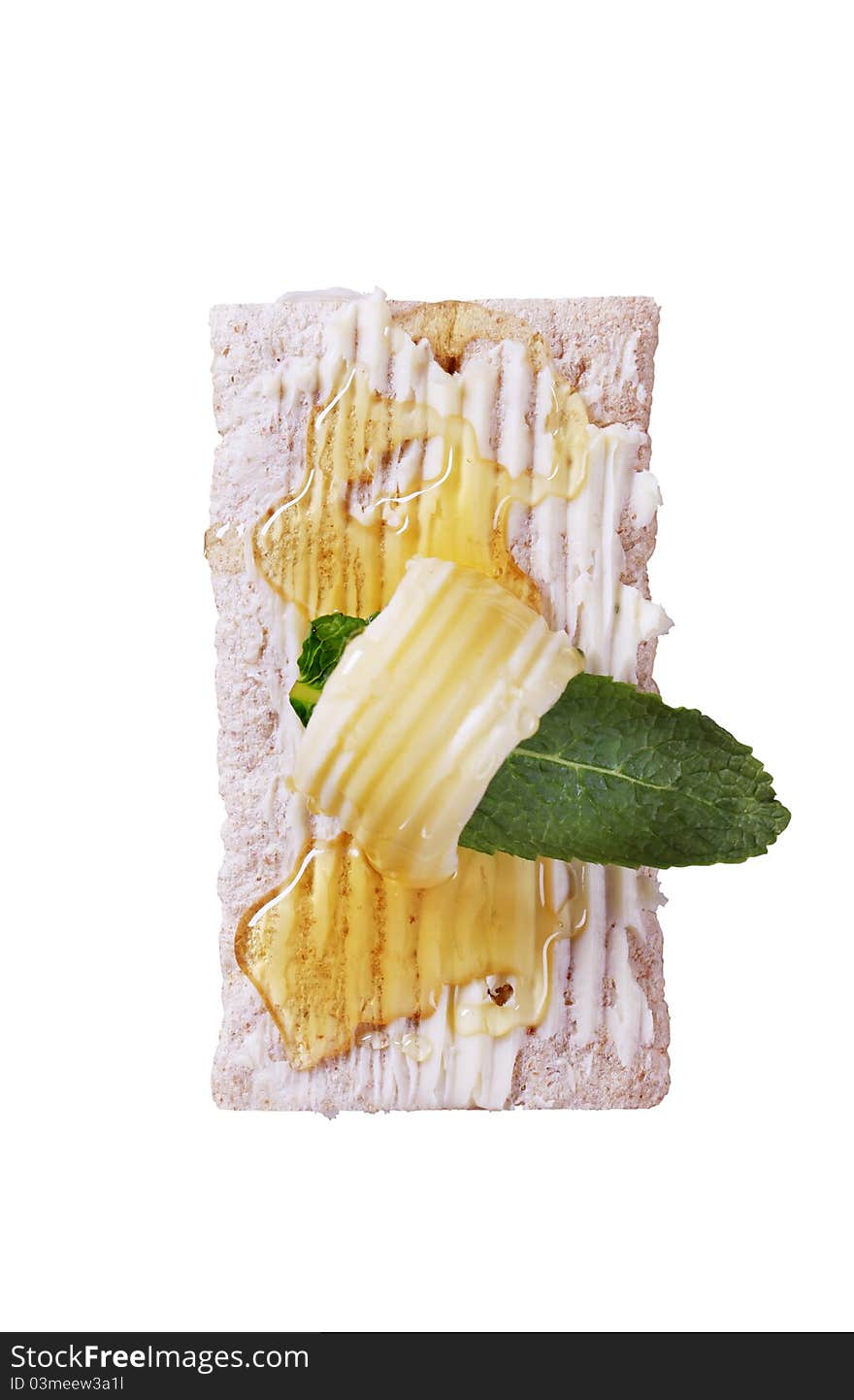 Slice of crispbread, butter and honey - overhead, cut out on white. Slice of crispbread, butter and honey - overhead, cut out on white