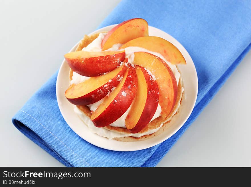 Pancakes with sweet cheese and fresh nectarine