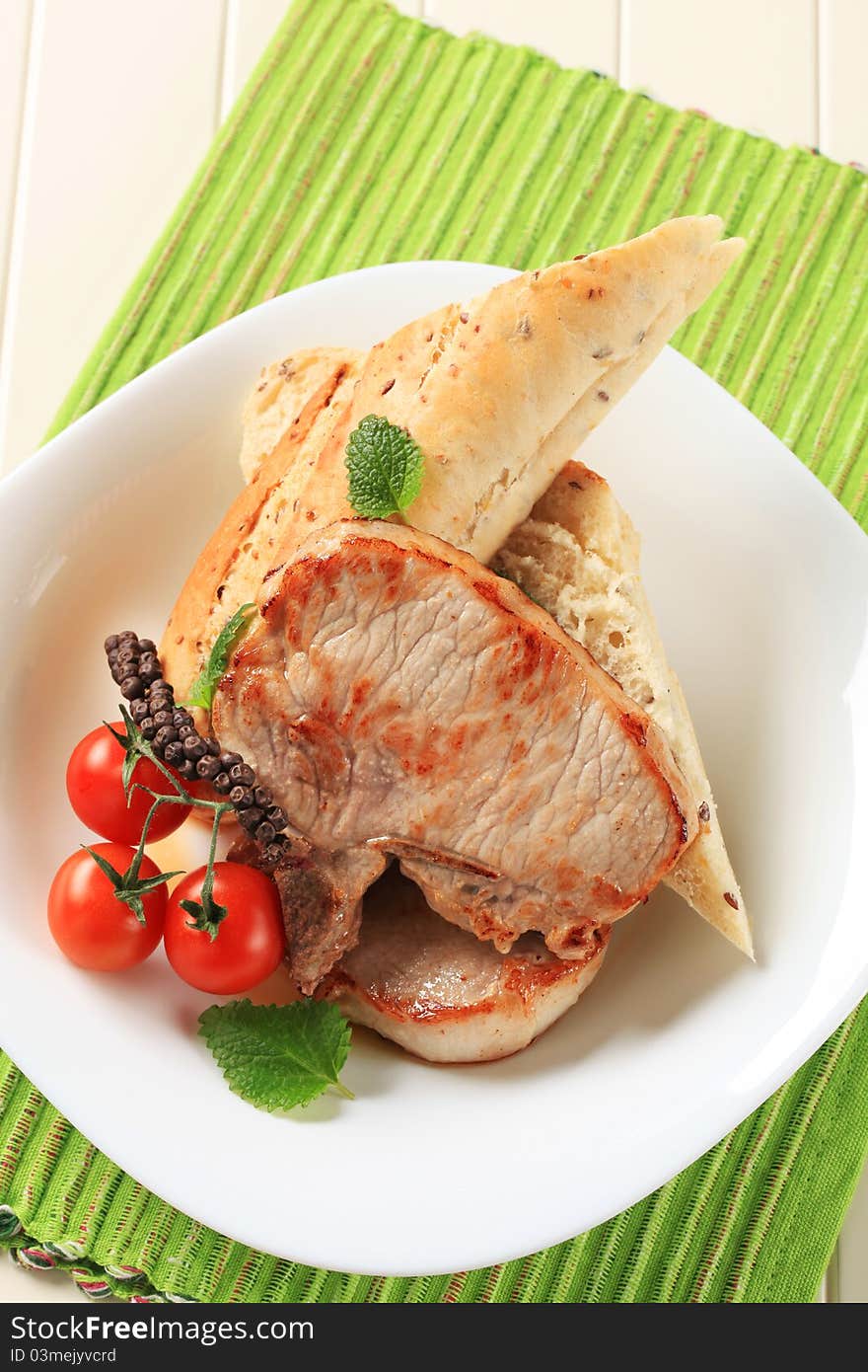 Juicy pork chops and whole wheat roll. Juicy pork chops and whole wheat roll