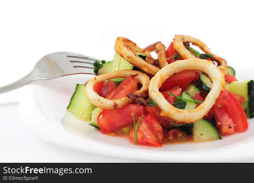 Squid salad in a plate with fork on white