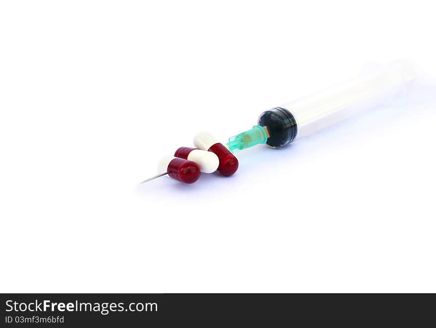 Medical pills and syringe on white background.