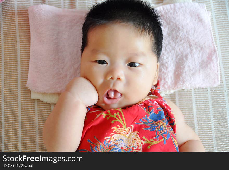 A 2 months chinese Baby girl lying on the bed