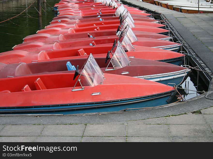 Red and blue paddleboats on a lake