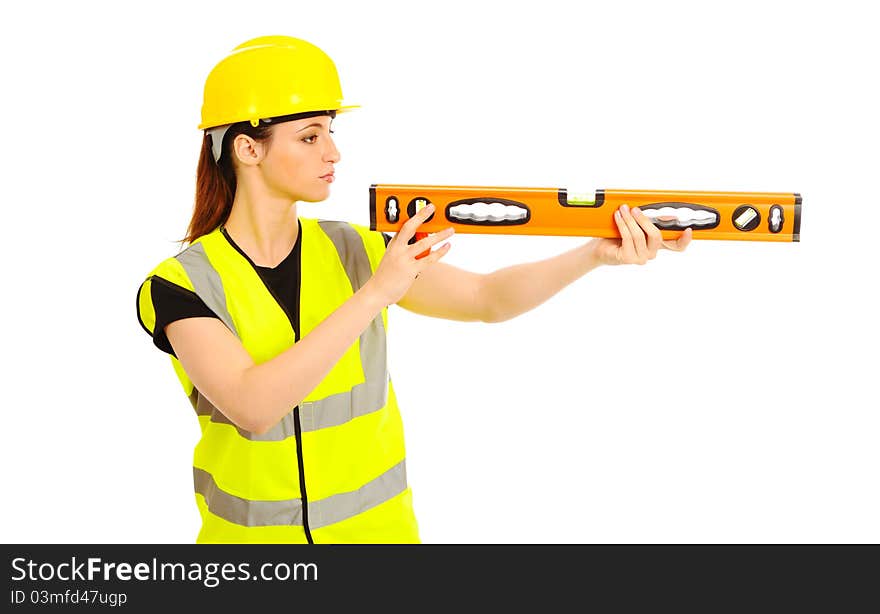 A females dressed in a high visibility vest looking along a spirit level on isloated white background. A females dressed in a high visibility vest looking along a spirit level on isloated white background