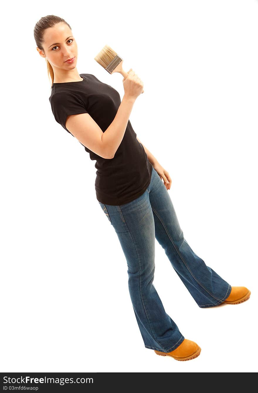 A young femaled dressed in blue jeans and black top holding a paint brush on isloated white background. A young femaled dressed in blue jeans and black top holding a paint brush on isloated white background