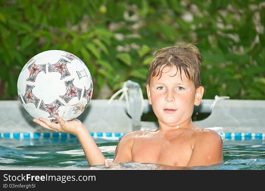 Boy in the pool holding a ball