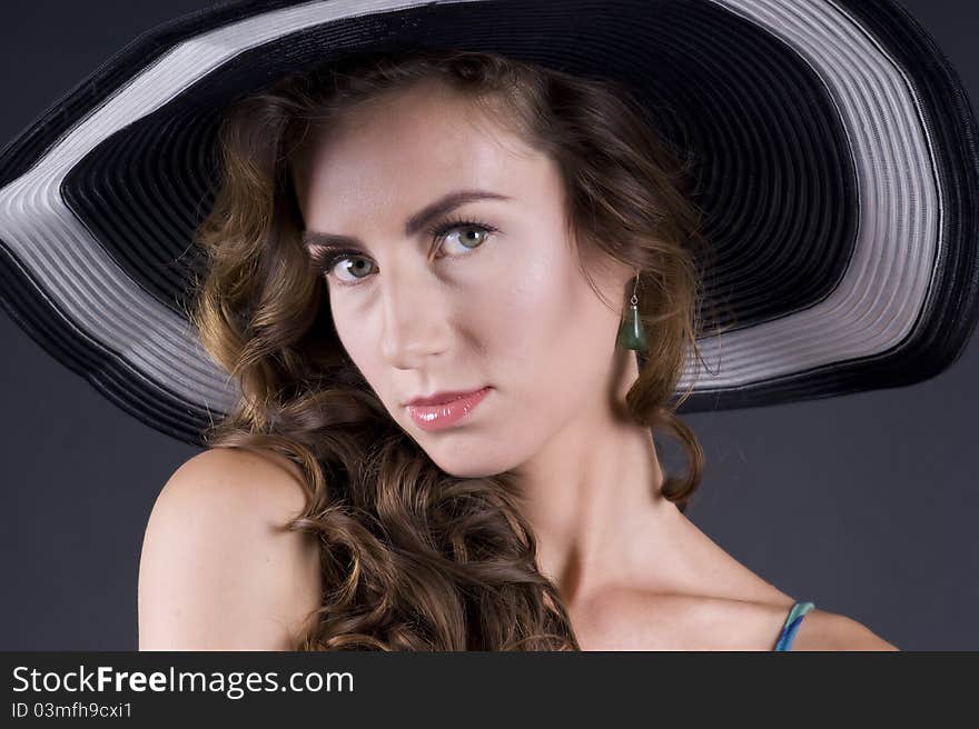 Portrait of a young beautiful woman in black soiledl on a gray background closeup. Portrait of a young beautiful woman in black soiledl on a gray background closeup