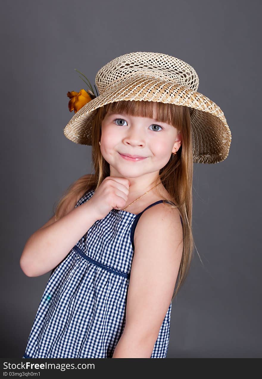 Little girl in a dress with a straw hat