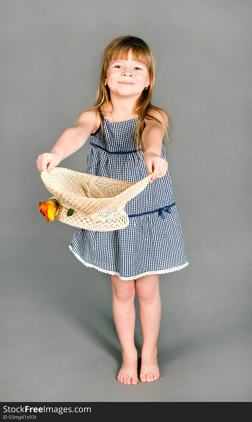 Little Girl In A Dress With A Straw Hat