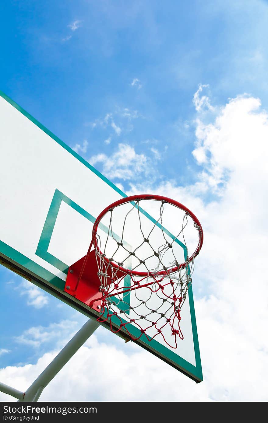 Outdoor basketball hoop on blue sky background