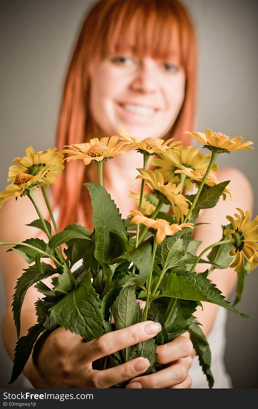 Beautiful young redhead girl with yellow flower