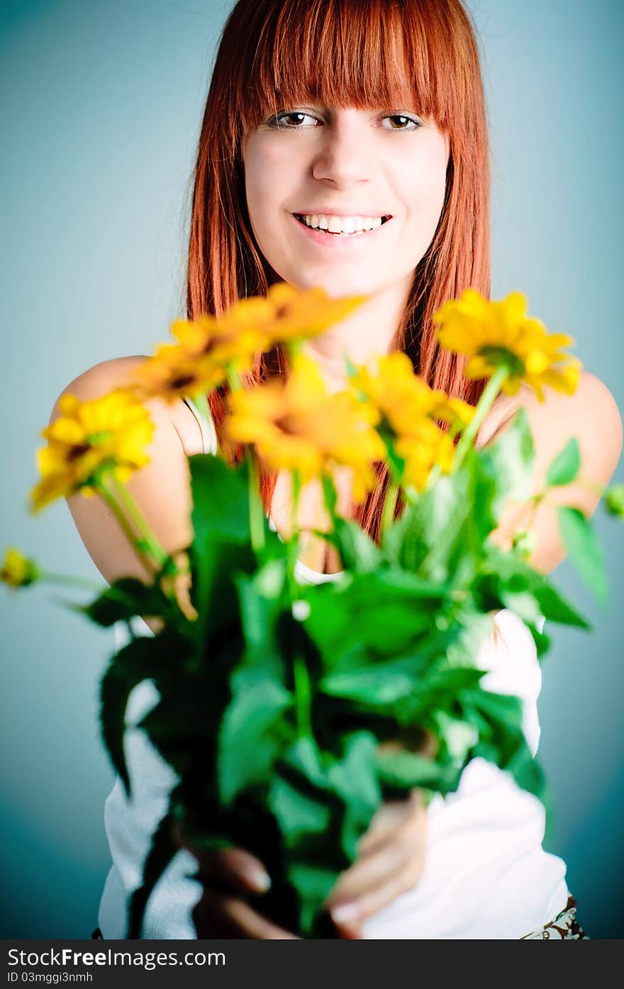 Beautiful young redhead girl with yellow flower