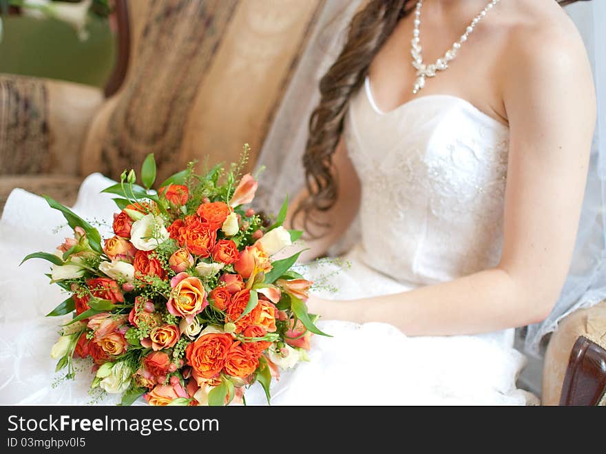 Bride holding bouquet of red and orange roses