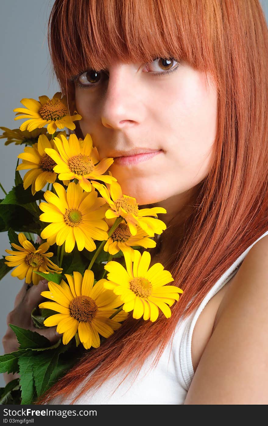 Beautiful young redhead girl with yellow flower