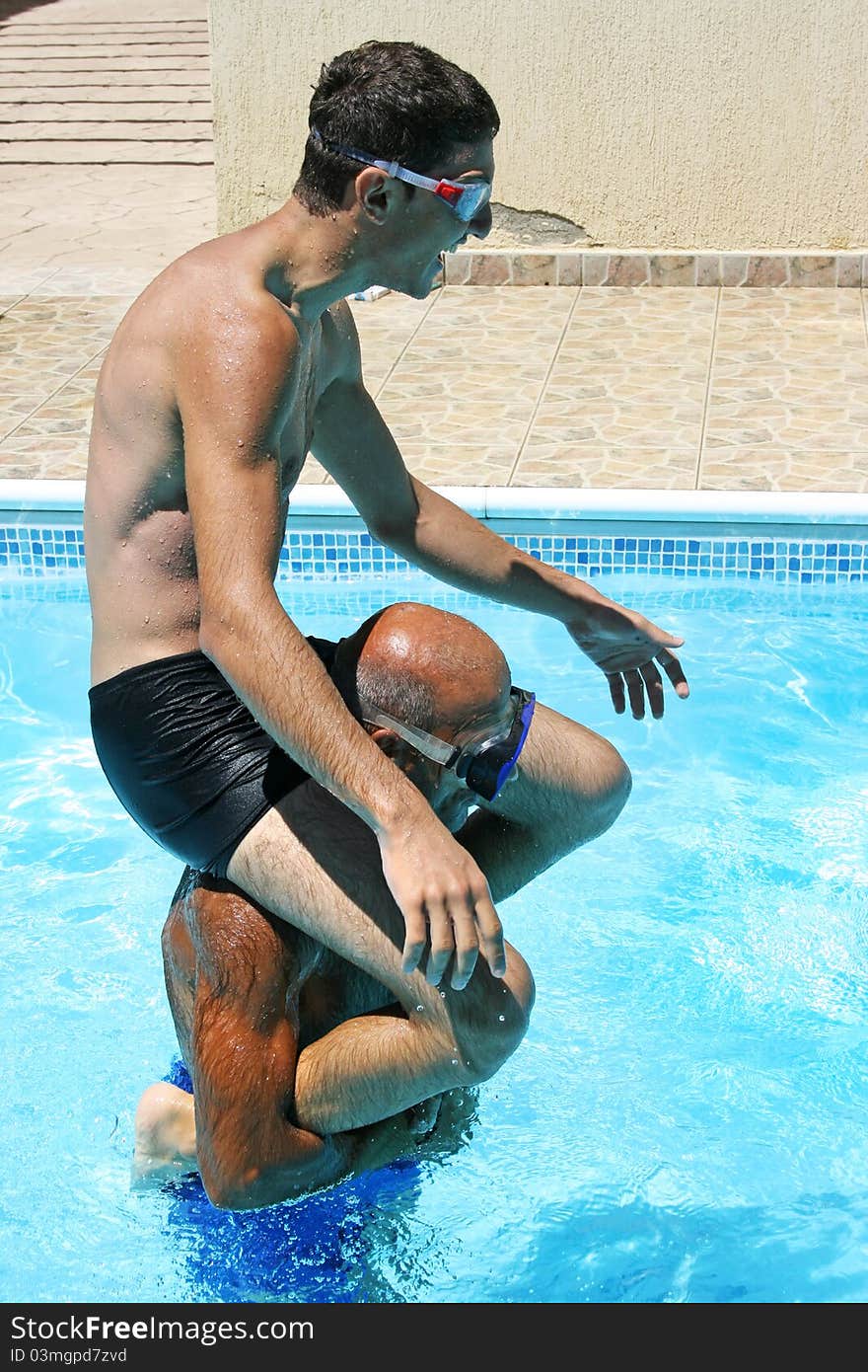 Men having fun  in swimming pool. Men having fun  in swimming pool.