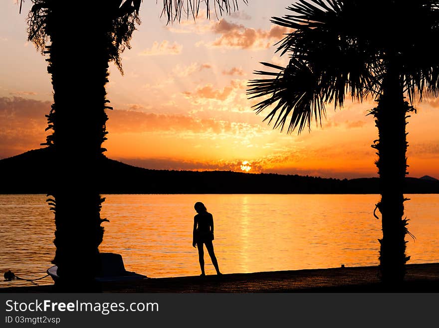 Girl silhouette on sunset background