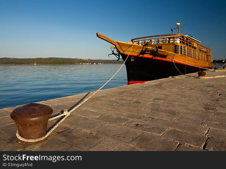 Old wooden boat tied with rope at seacoast