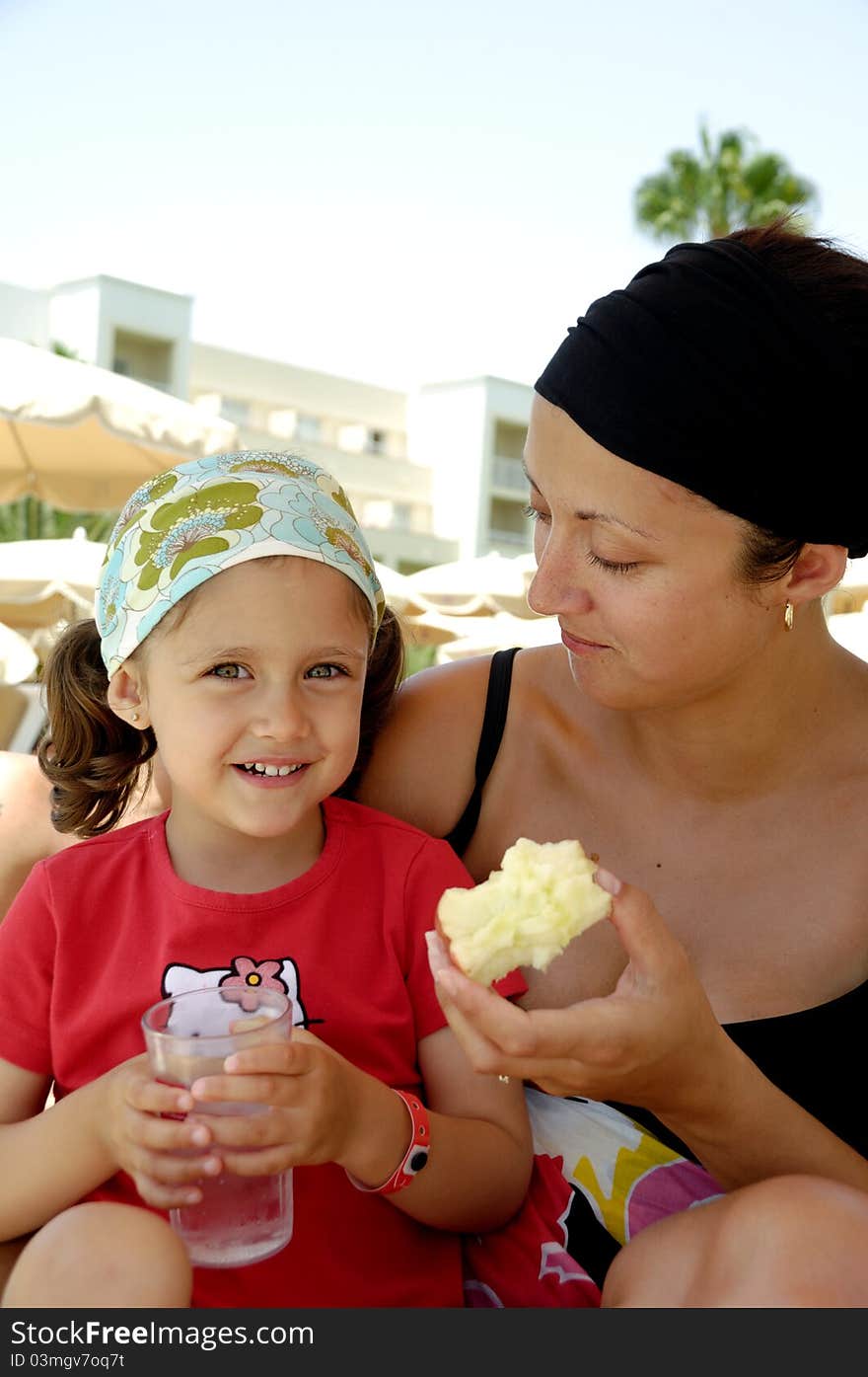 Healthy family. Mother and child eating apple and drinking water. Healthy family. Mother and child eating apple and drinking water