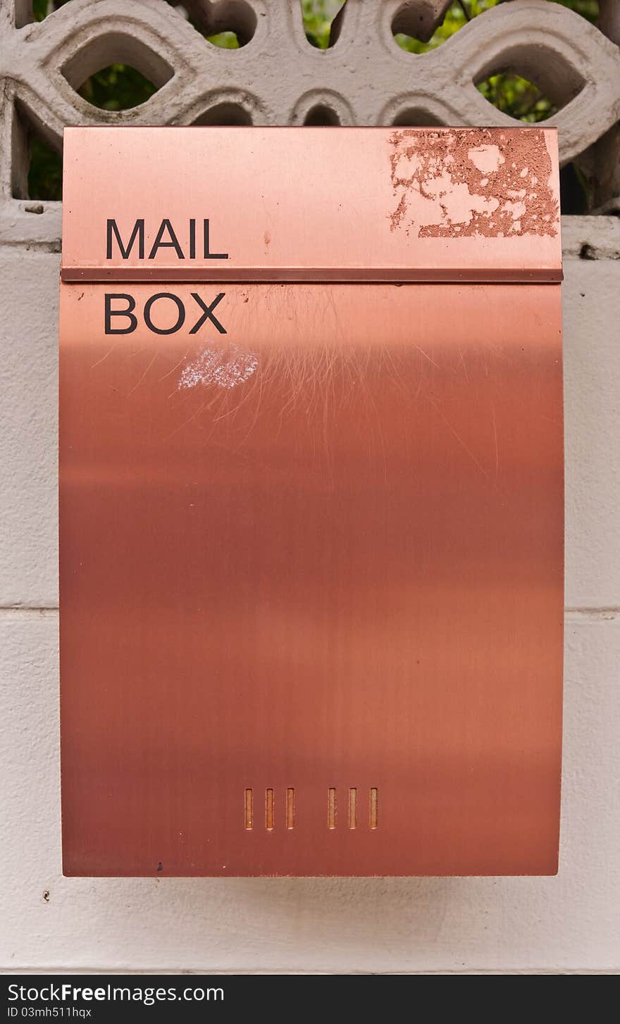 Orange brown metal mailbox on wall