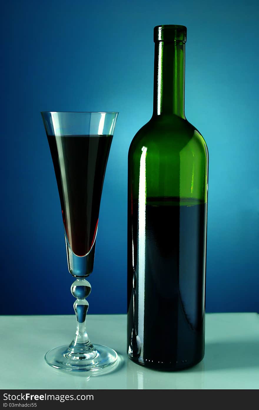 Wine bottle and glass on a blue background