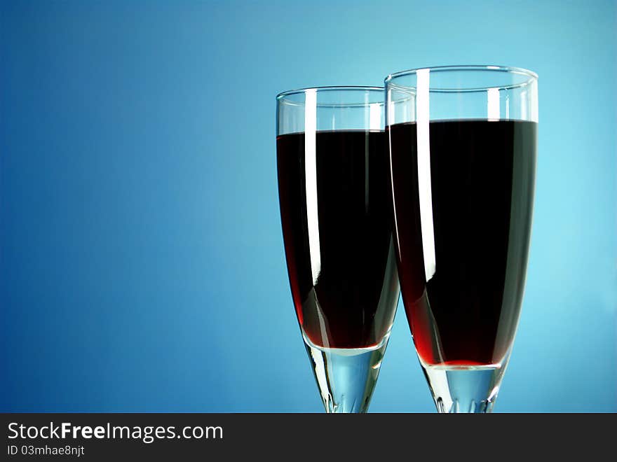 Two glasses of red wine on a blue background. Two glasses of red wine on a blue background