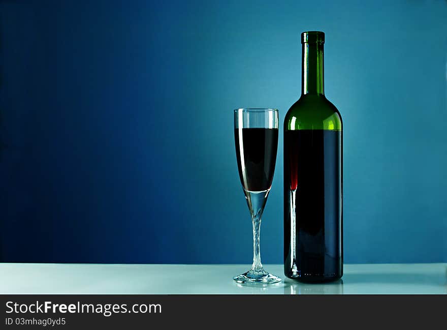 Wine Bottle And Glass On A Blue Background