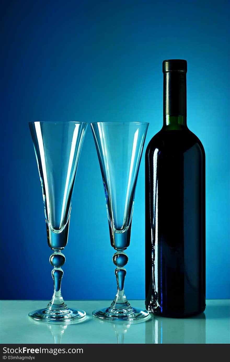 Wine bottle and glass on a blue background