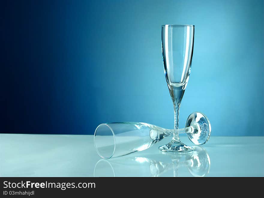 Two empty glasses on a blue background. Two empty glasses on a blue background