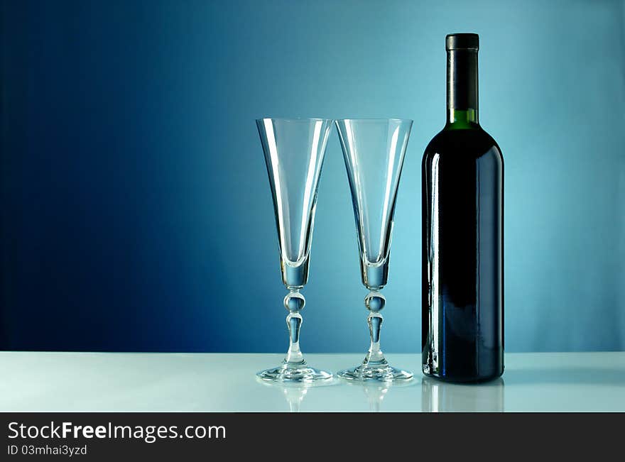 Wine bottle and glass on a blue background