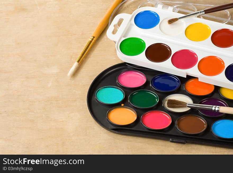 Paint brush and painters palette on wooden background