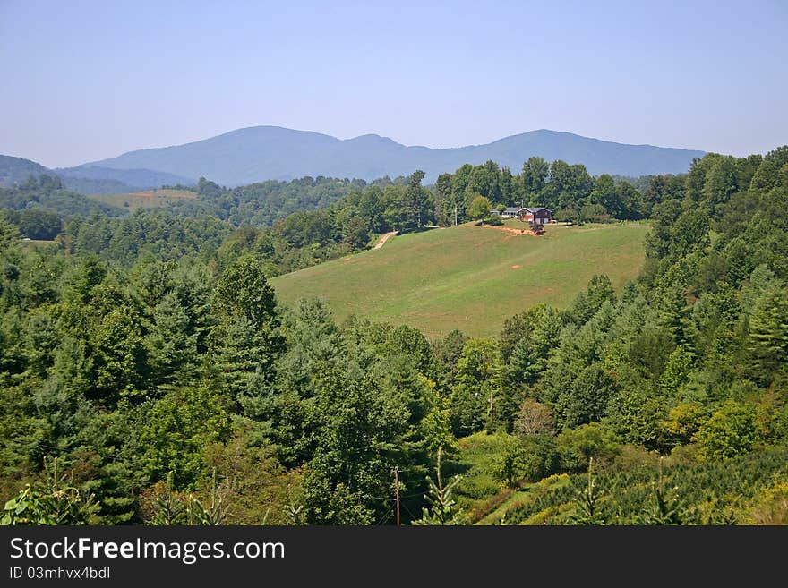 A single house surrounded by woods and mountains. A single house surrounded by woods and mountains