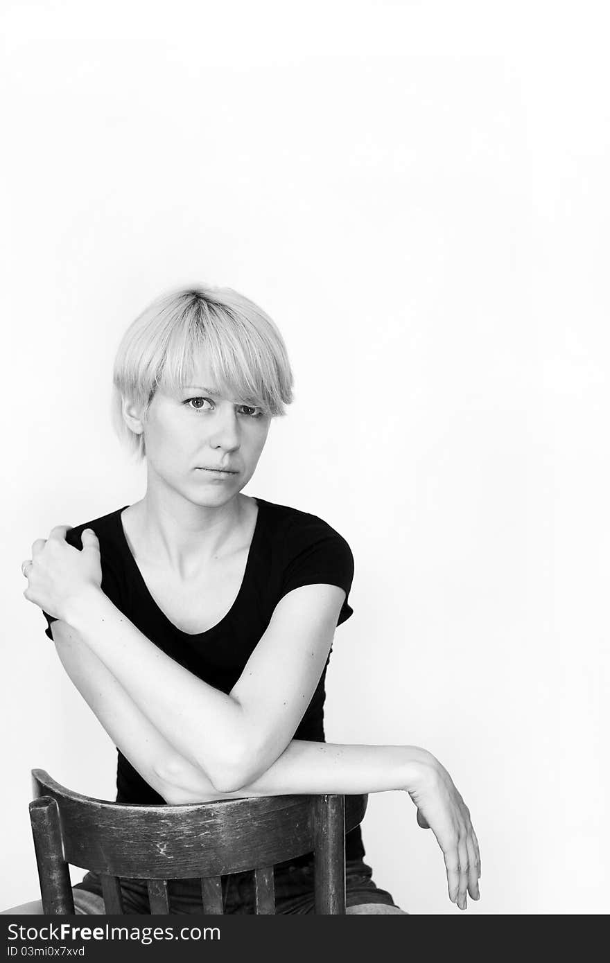 A young pretty woman sitting on a chair, for white background.