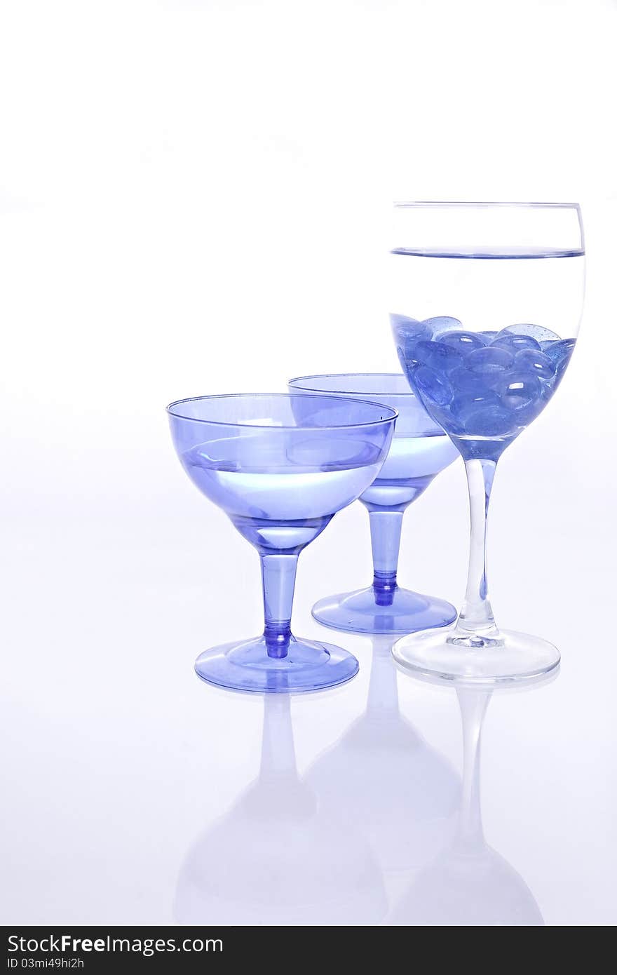 Blue wine Glasses with water and blue glass pebbles