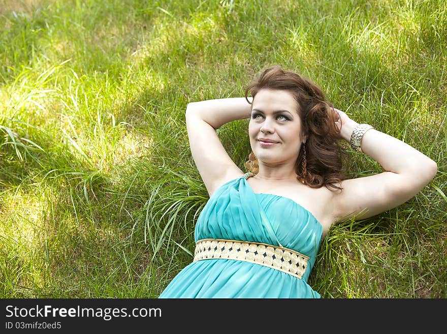 Pretty girl relaxing outdoor in green grass