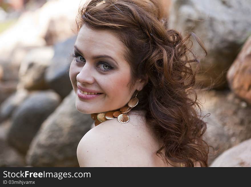 Girl with flowing hair on the background of rocks