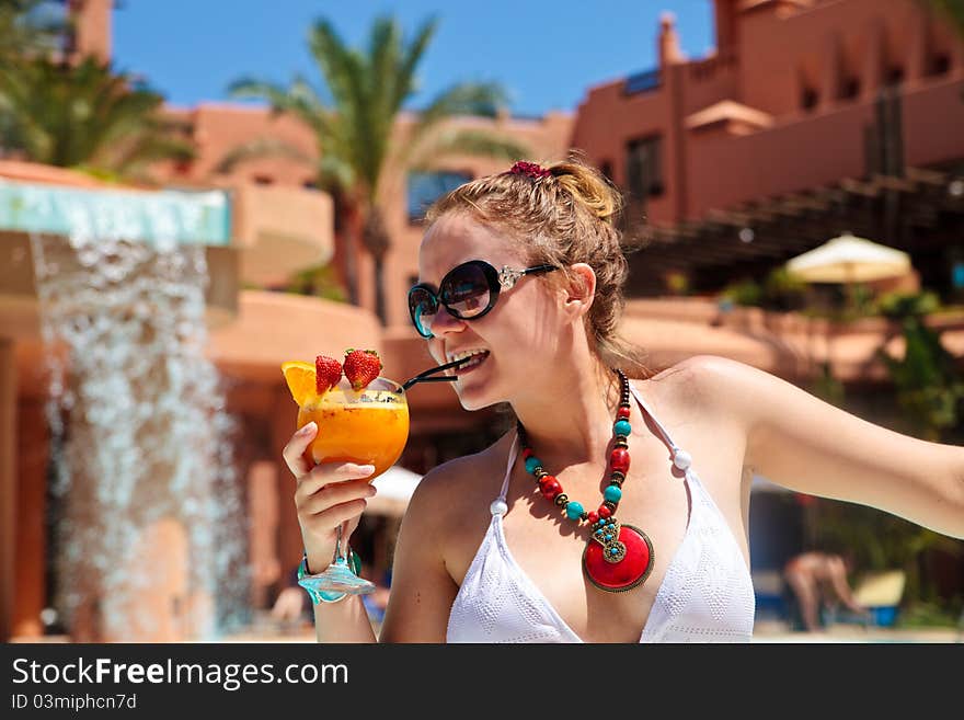 Beautiful woman in bikini holding cocktail