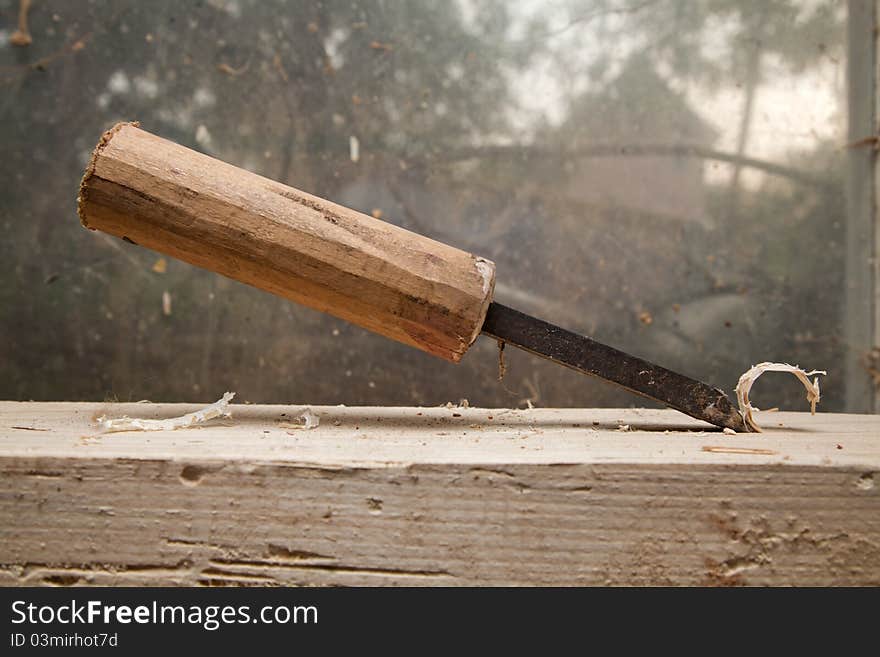 Hammer and nail on wood chunck on top of each other