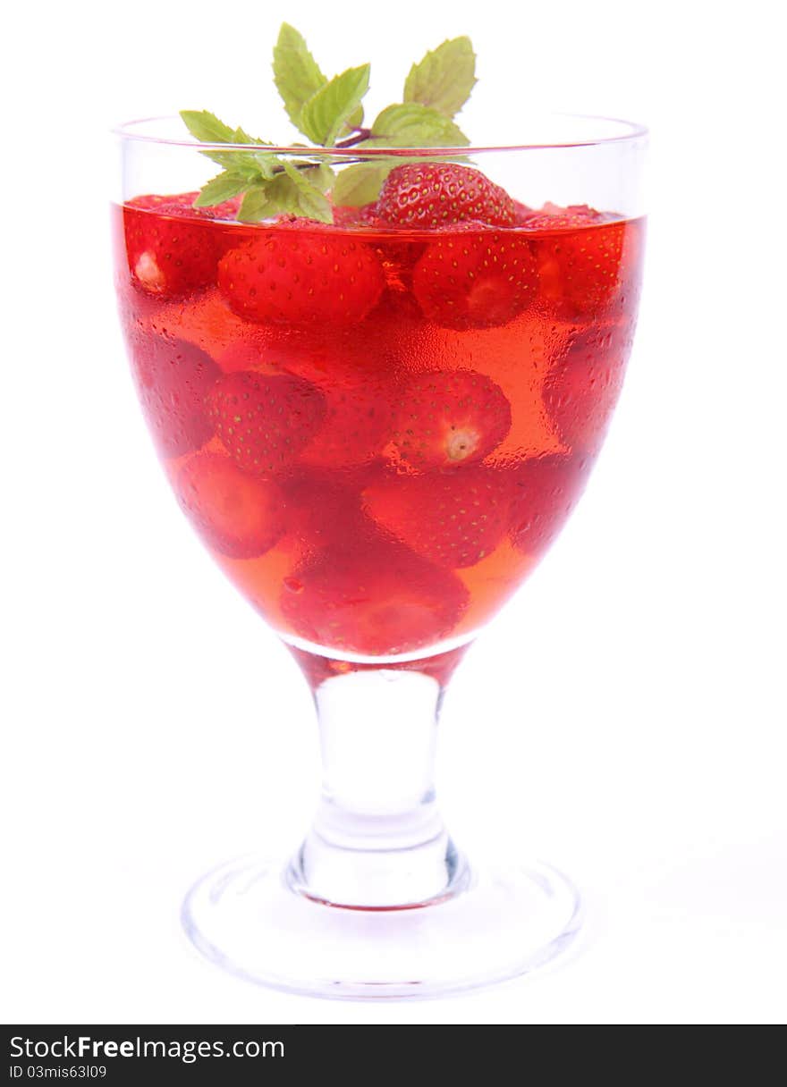 Jelly with strawberries decorated with a mint twig in a glass cup. Jelly with strawberries decorated with a mint twig in a glass cup