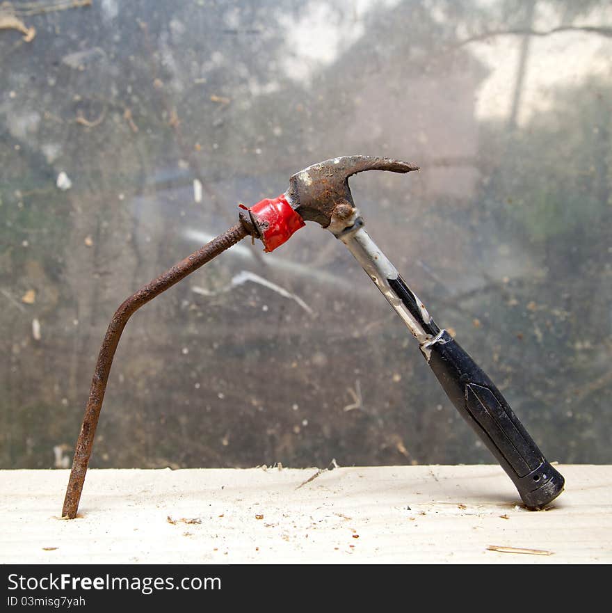 Hammer and nail on wood chunk on top of each other