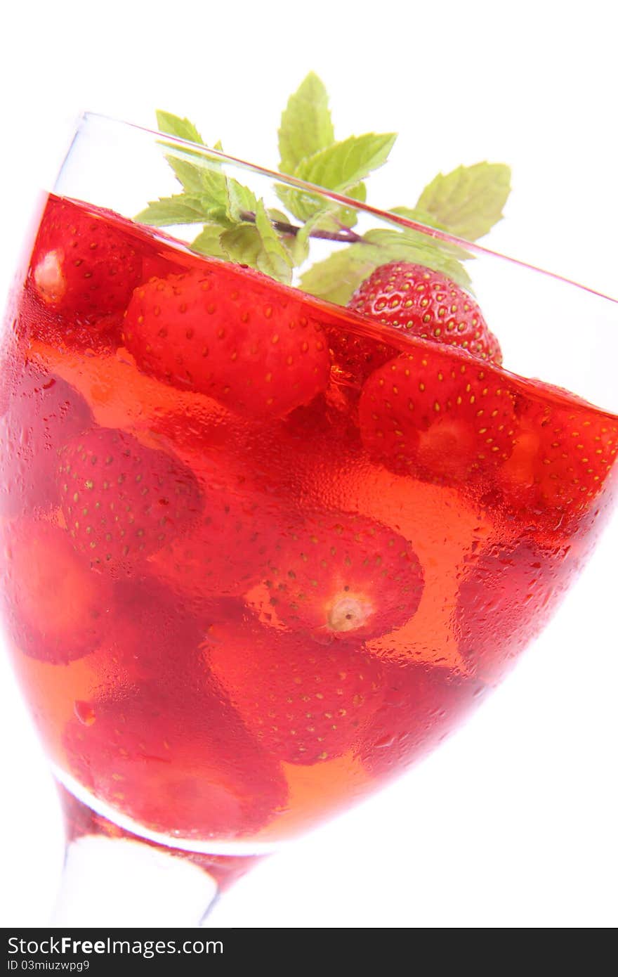 Jelly with strawberries decorated with a mint twig in a glass cup. Jelly with strawberries decorated with a mint twig in a glass cup