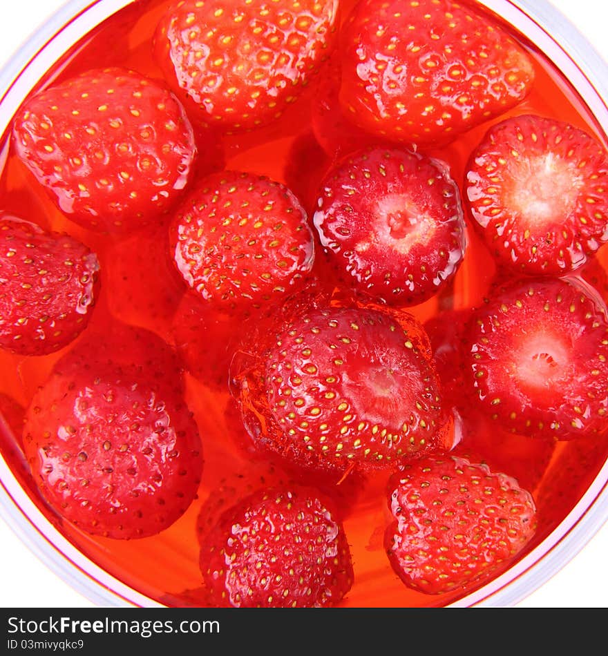 Jelly with strawberries in a glass cup in close up. Jelly with strawberries in a glass cup in close up